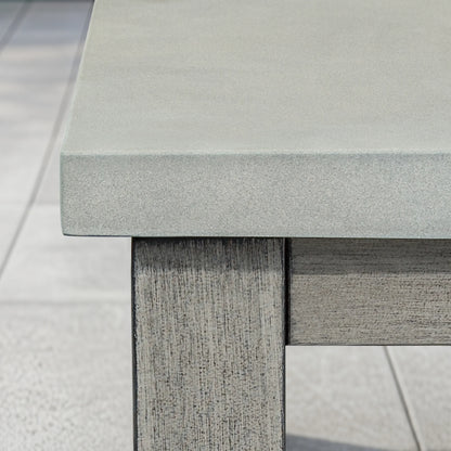 Close-up of a textured concrete table with wood-look legs on a light gray background