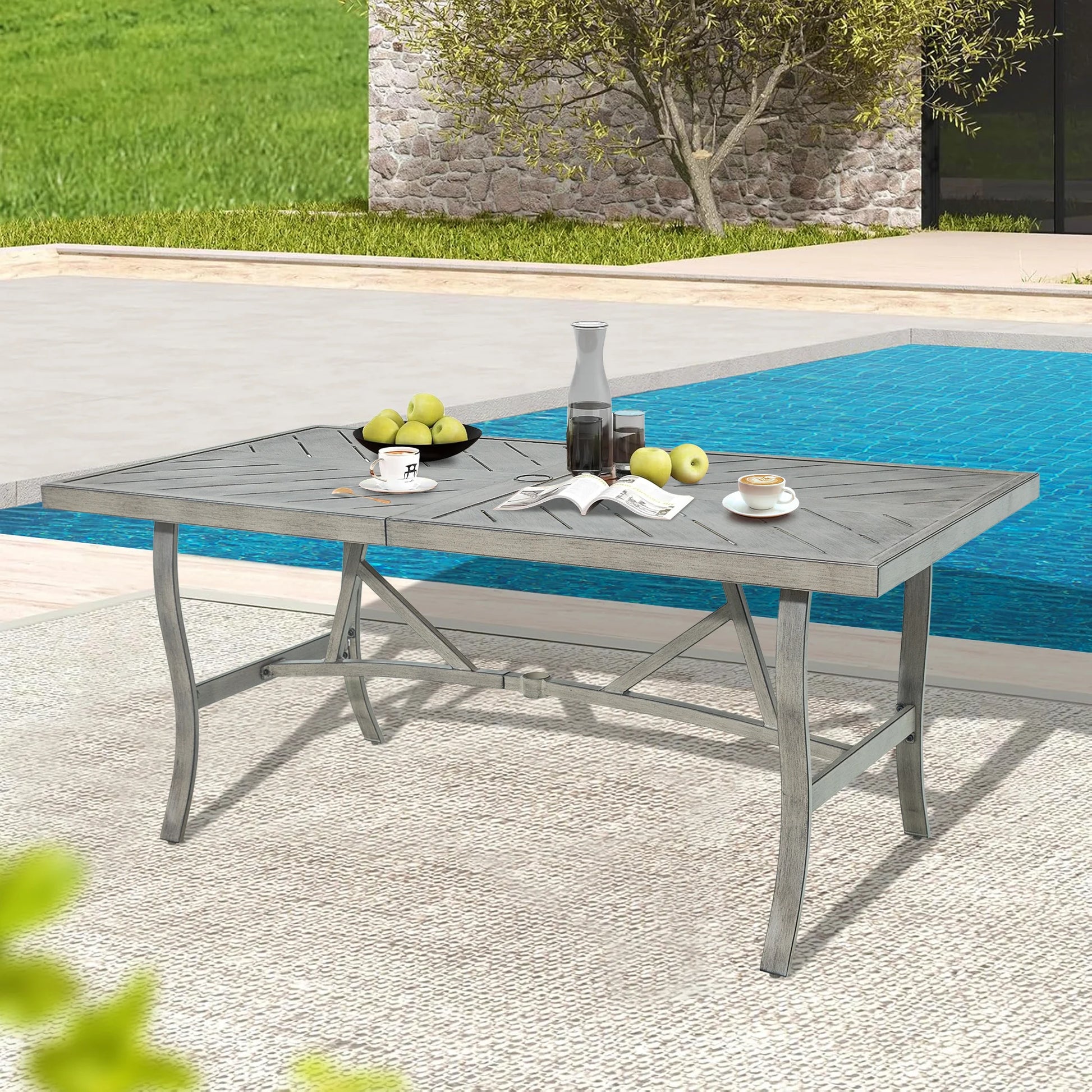Outdoor dining table with fruit and glasses by a poolside