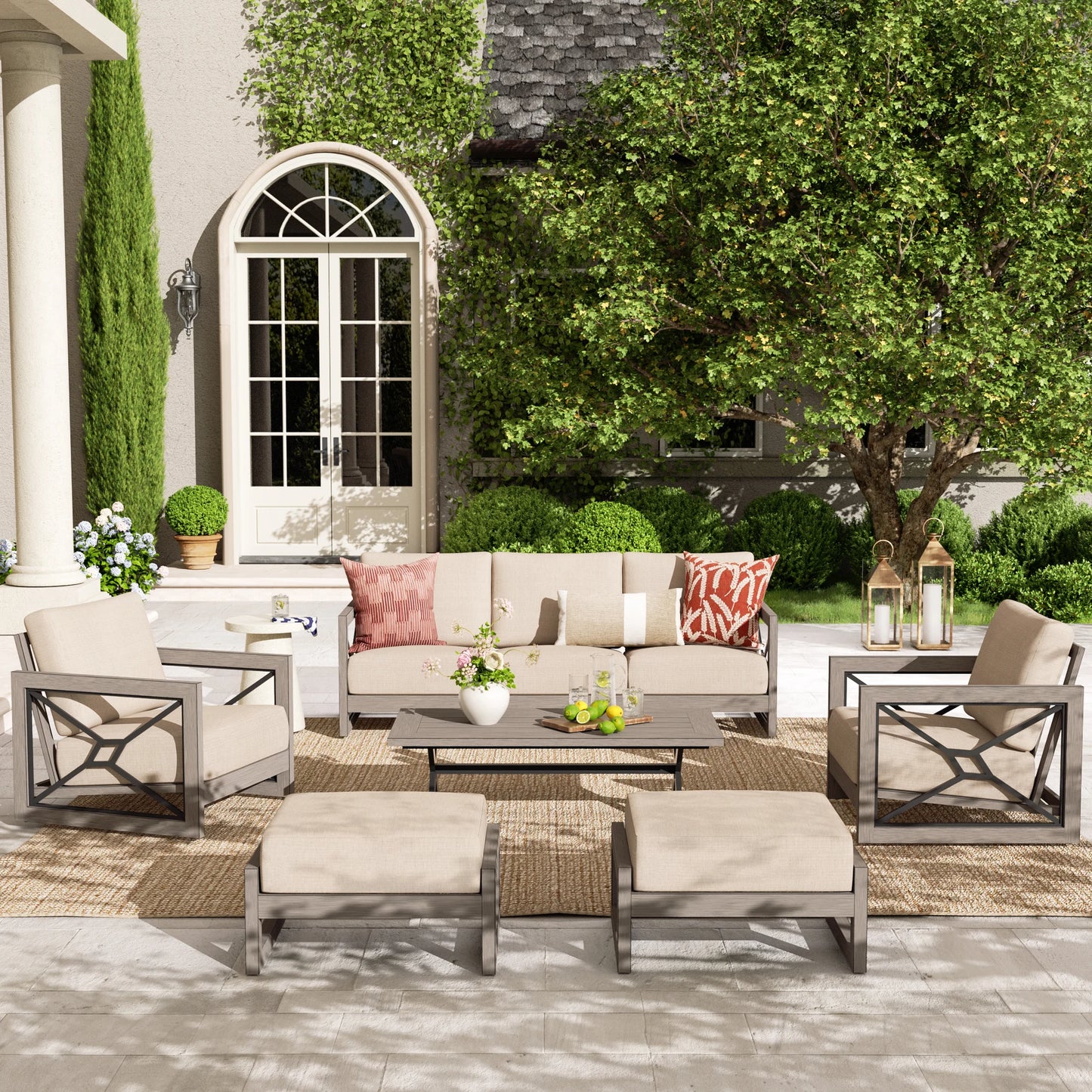 Outdoor patio set with beige furniture, cushions, and decorative items on a patio.