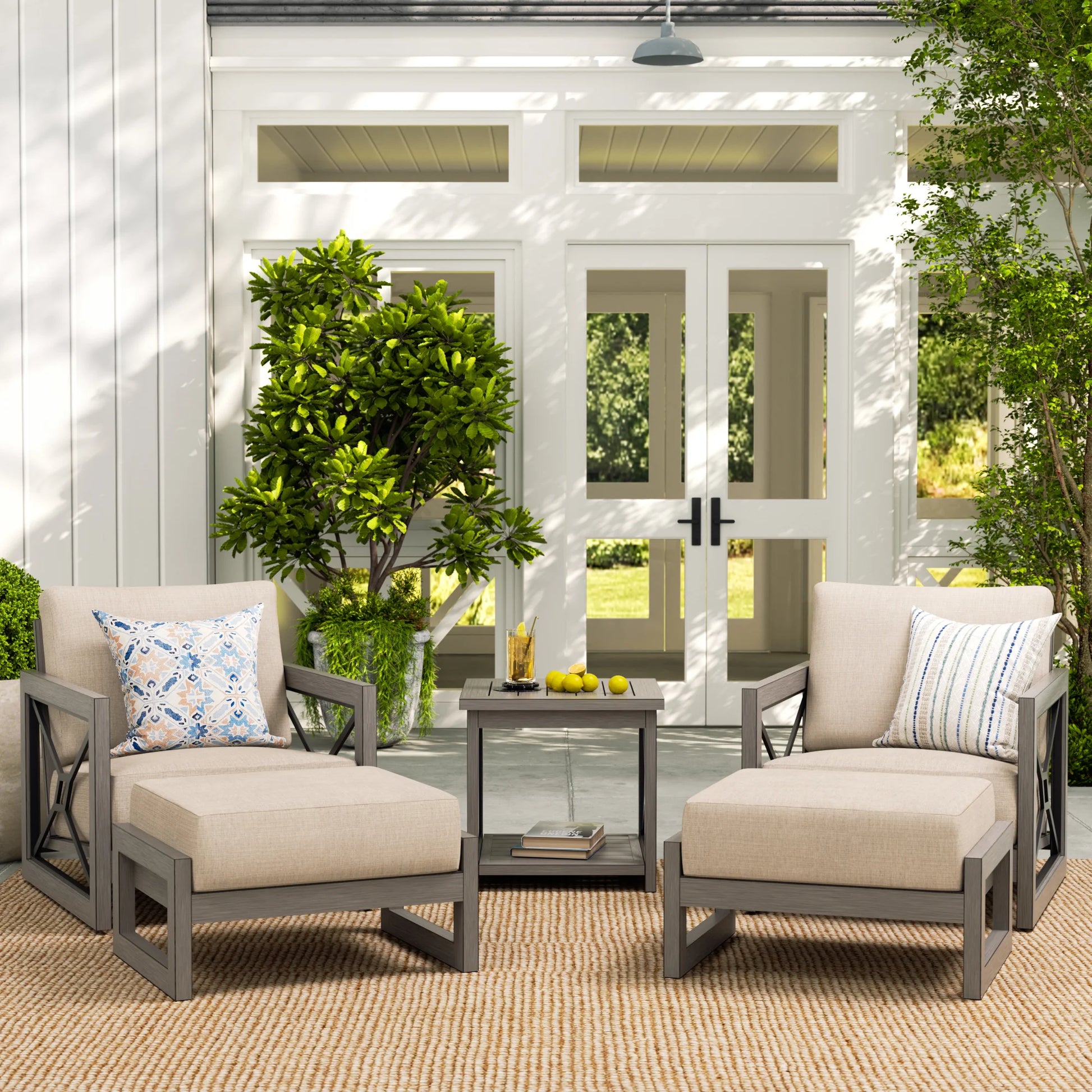 Outdoor patio set with chairs and table on a patio with plants and a door in the background.