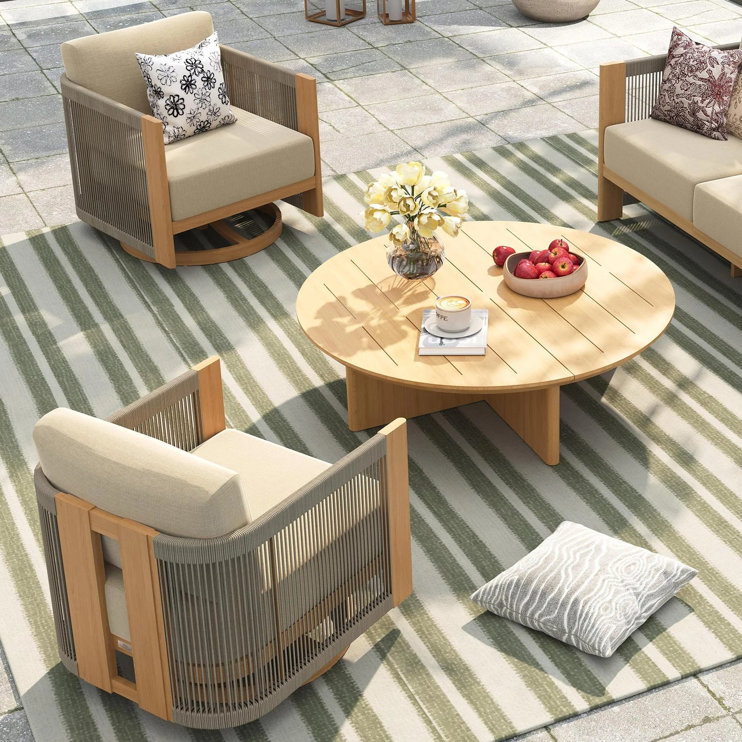 Outdoor patio furniture set with chairs, table, and cushions on a striped rug.