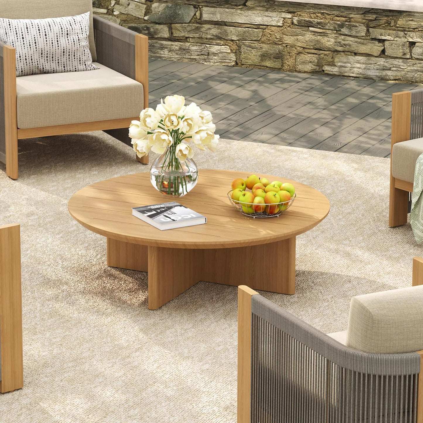 Outdoor patio setting with wooden coffee table, chairs, and decorative elements.