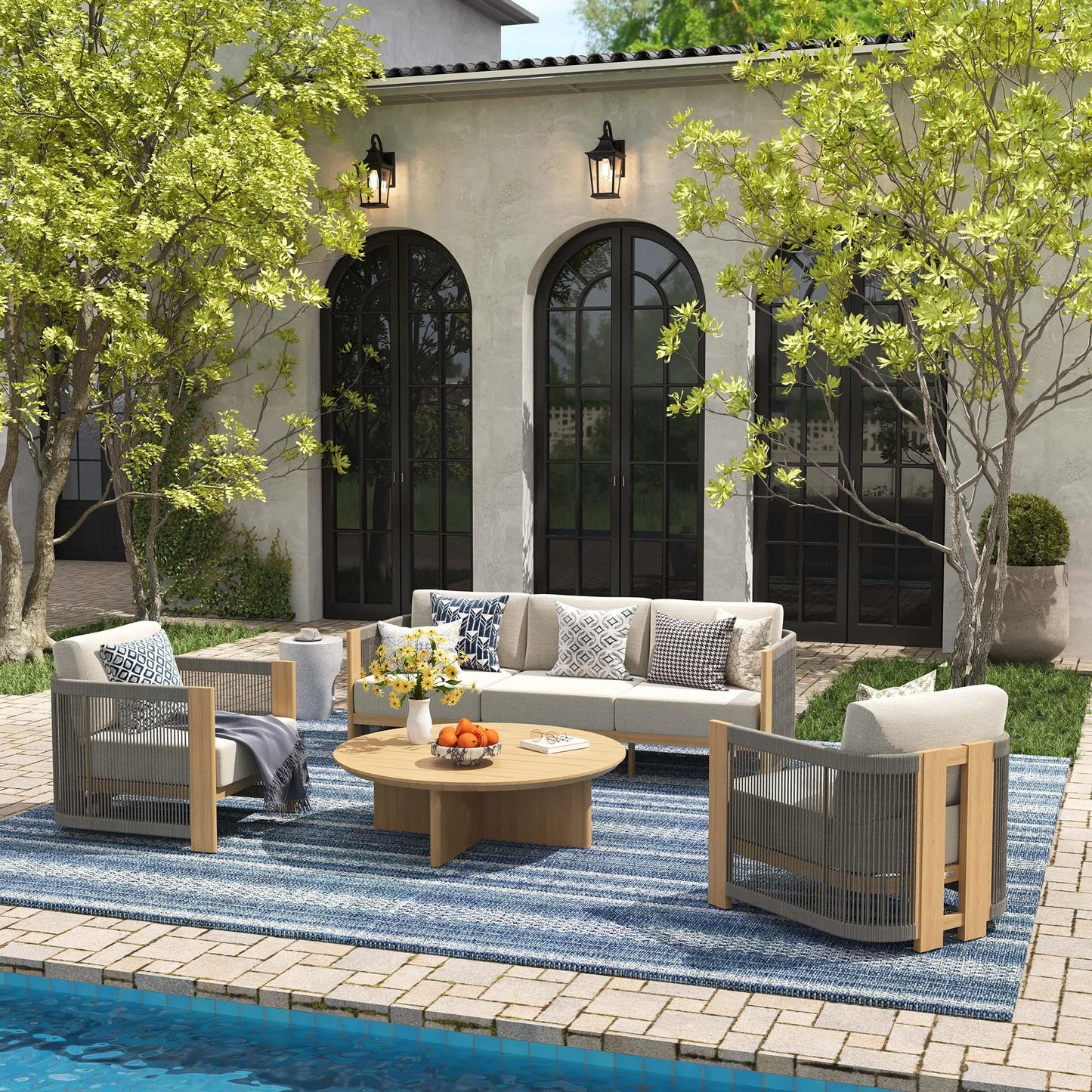 Outdoor patio set with furniture and decor by a poolside.