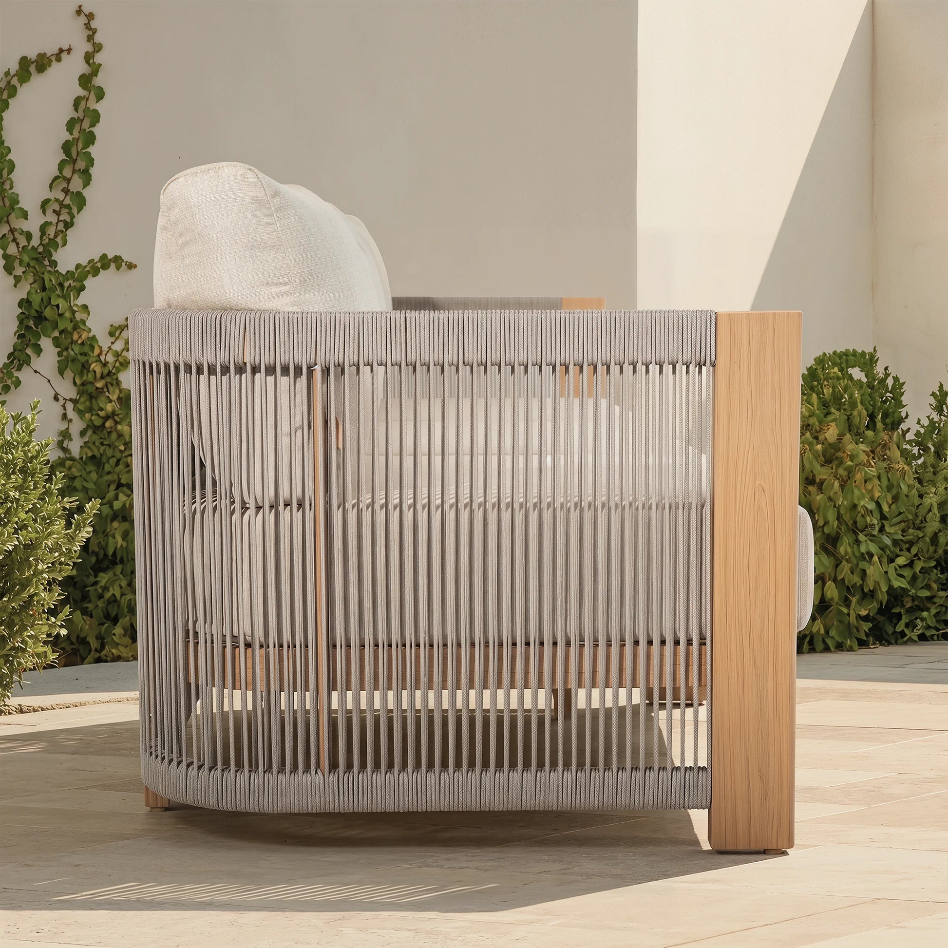 Modern outdoor chair with wood-look frame and woven backrest on a patio
