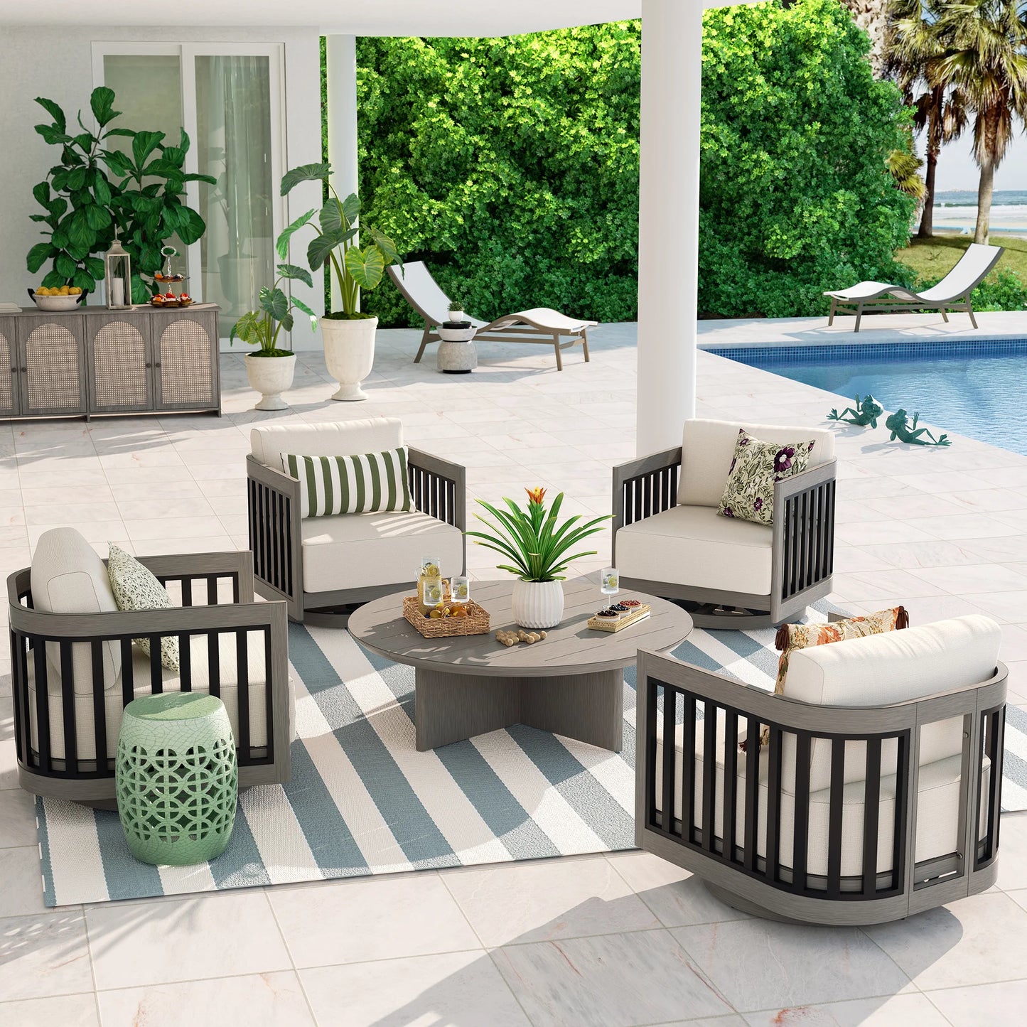 Outdoor patio furniture set with chairs, table, and cushions on a striped rug by a pool.