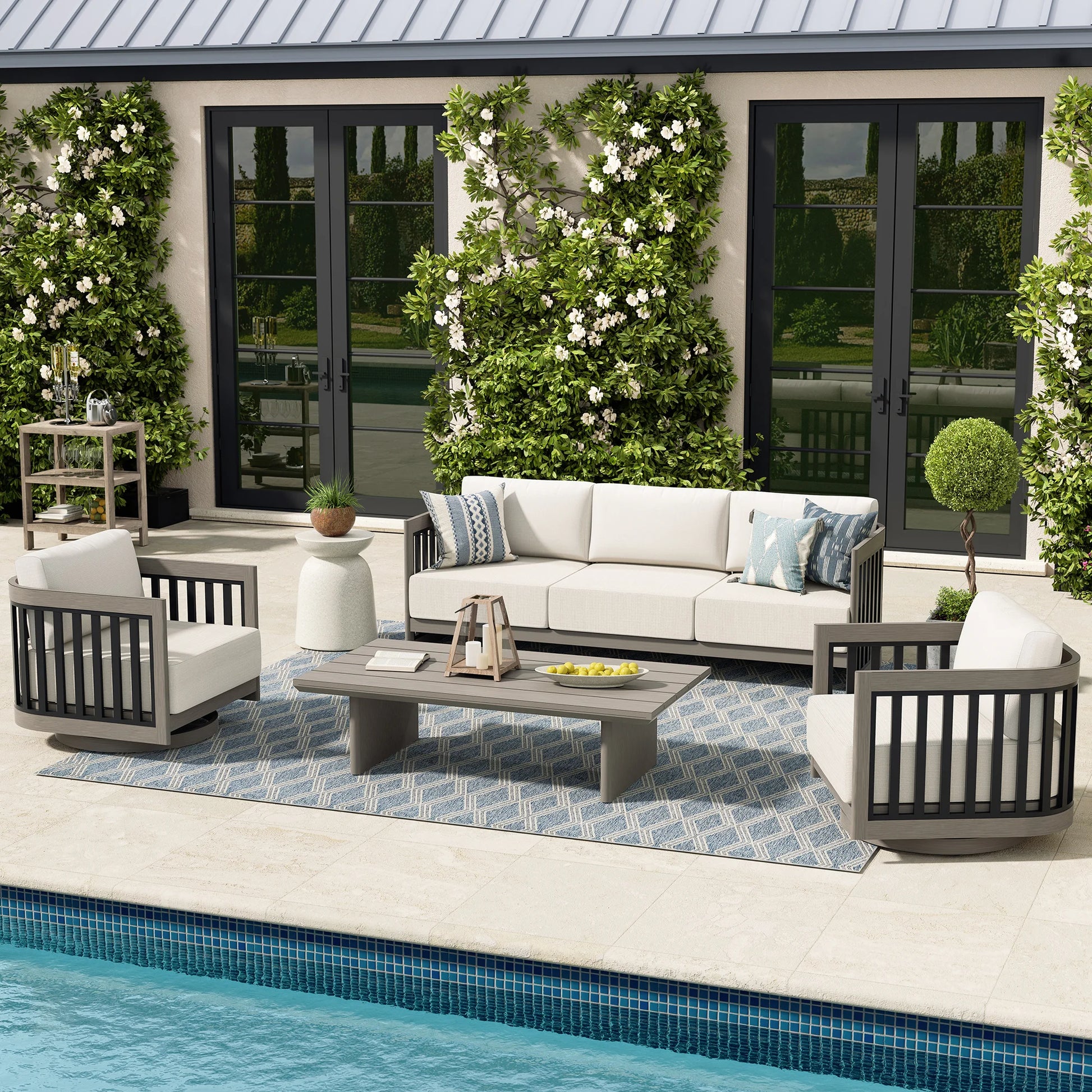 Outdoor patio set with sofa, chairs, and coffee table by a pool