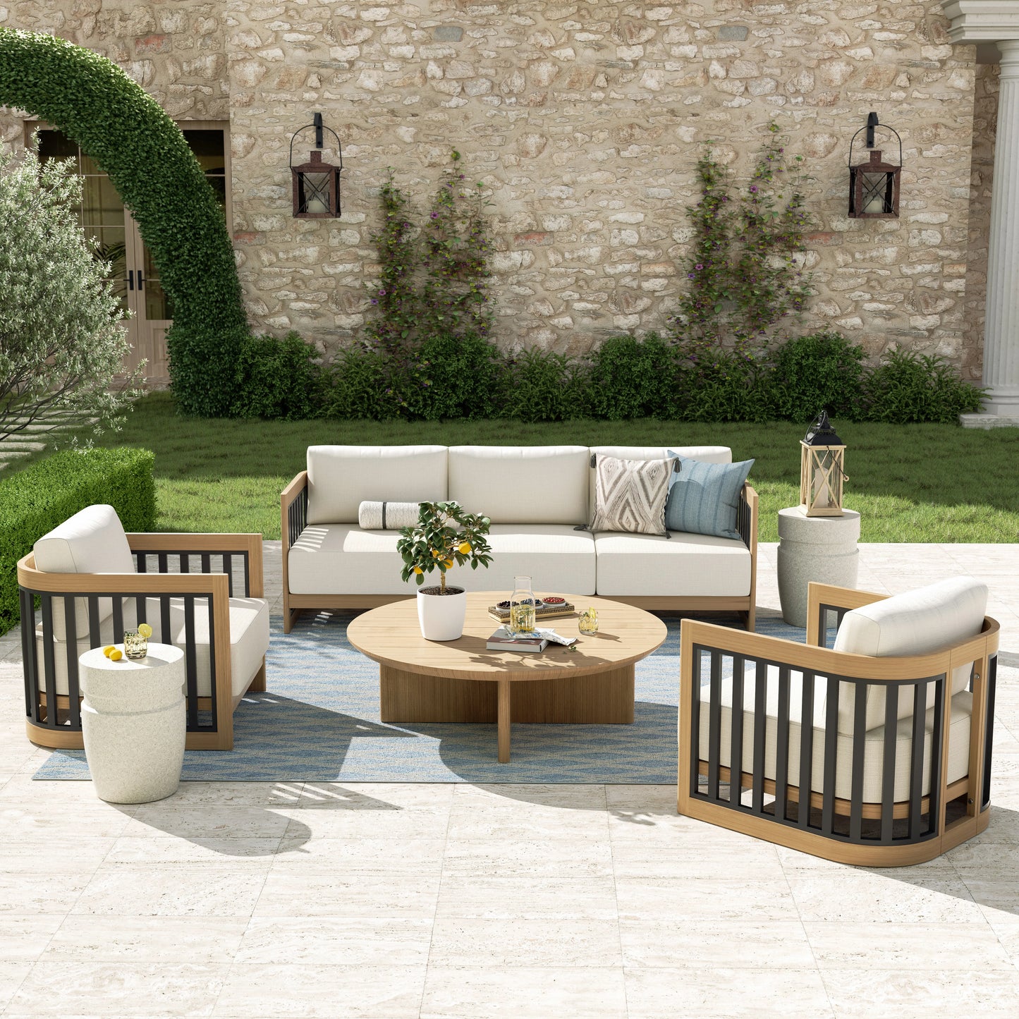 Outdoor patio set with furniture and decor against a stone wall.