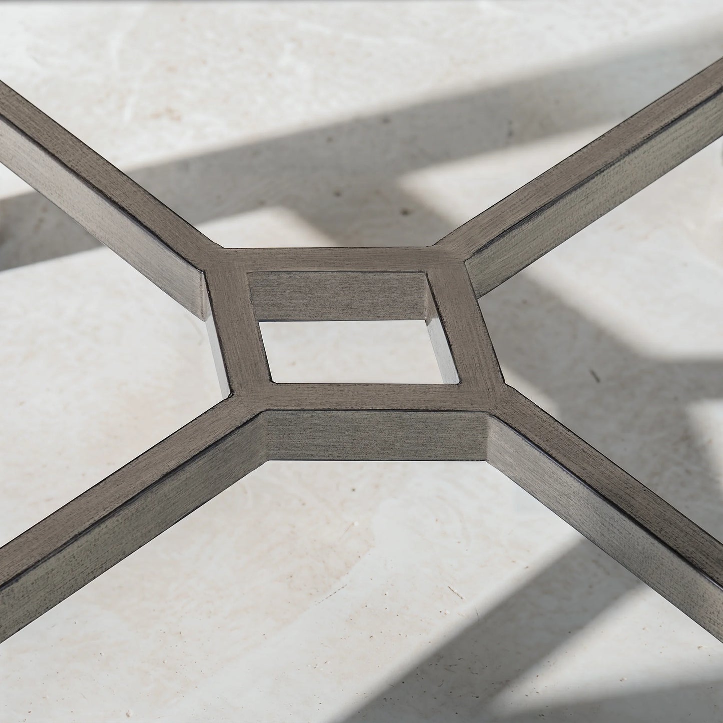 Close-up of a metal geometric floor design on a light stone floor.