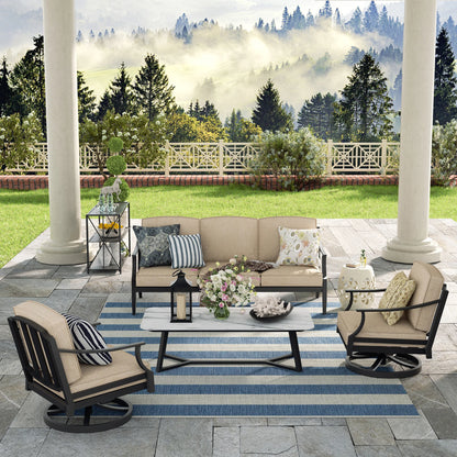 Outdoor patio set with furniture and decor on a stone patio with a scenic background.