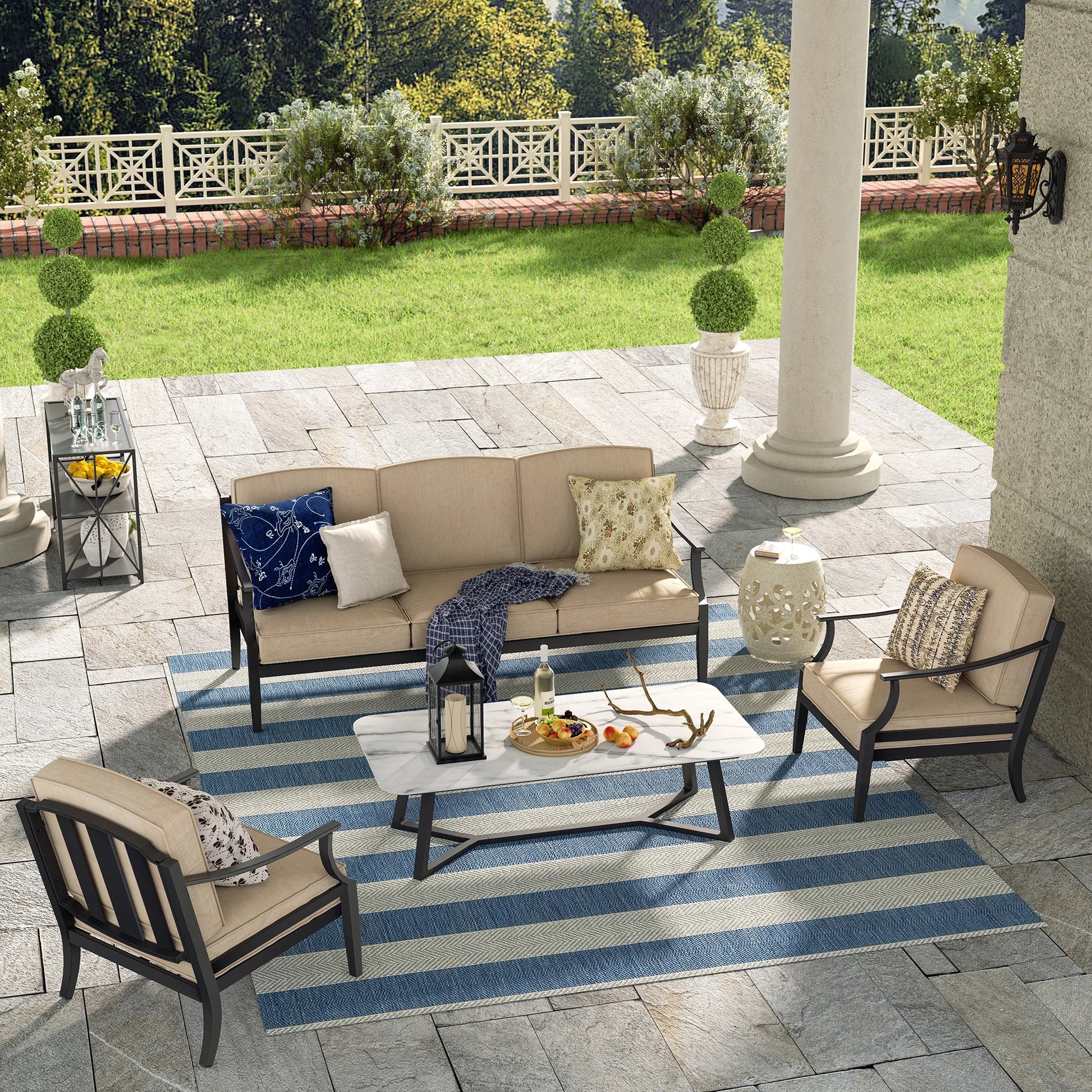 Outdoor patio set with furniture and decor on a striped rug.