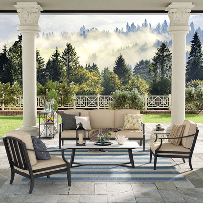 Outdoor patio set with furniture and decor on a stone patio with a scenic background.
