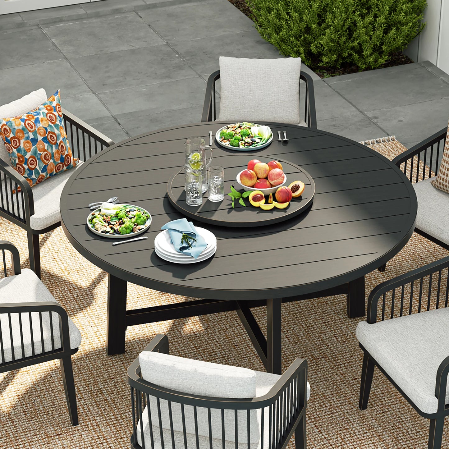 Round outdoor dining table with chairs and food on a patio