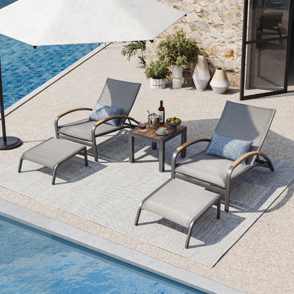 Outdoor patio set with lounge chairs, table, and umbrella by a poolside.