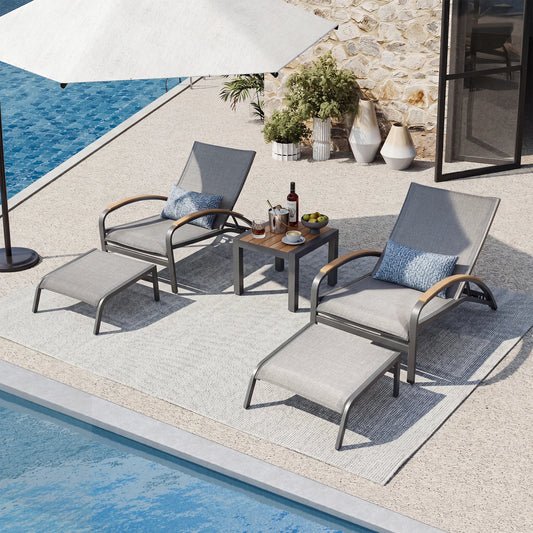 Outdoor patio set with lounge chairs, table, and umbrella by a poolside.