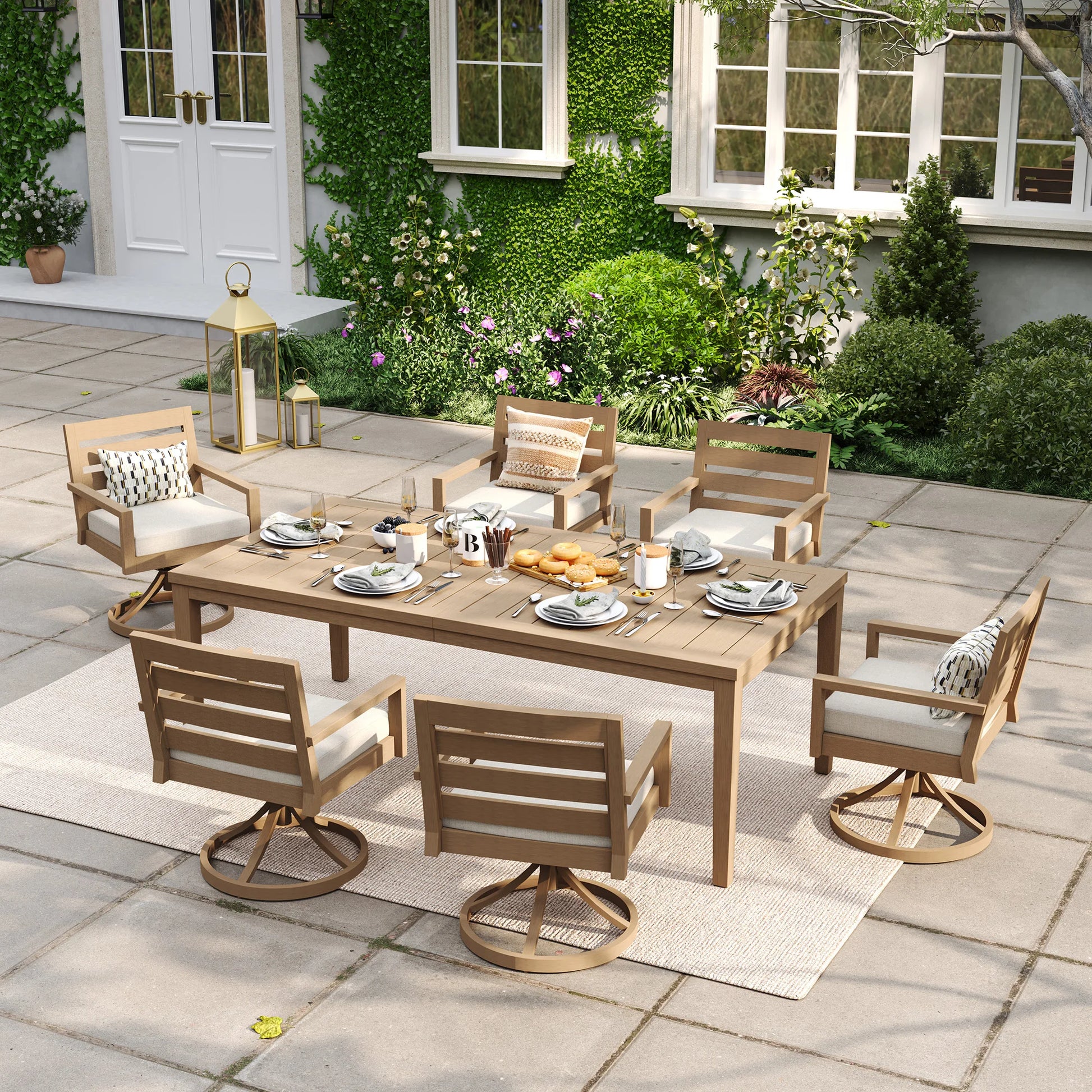 Alcudia 7-piece outdoor dining set with a rectangular faux wood table and six premium 360-degree swivel rocker chairs styled on a warm backyard stone patio.