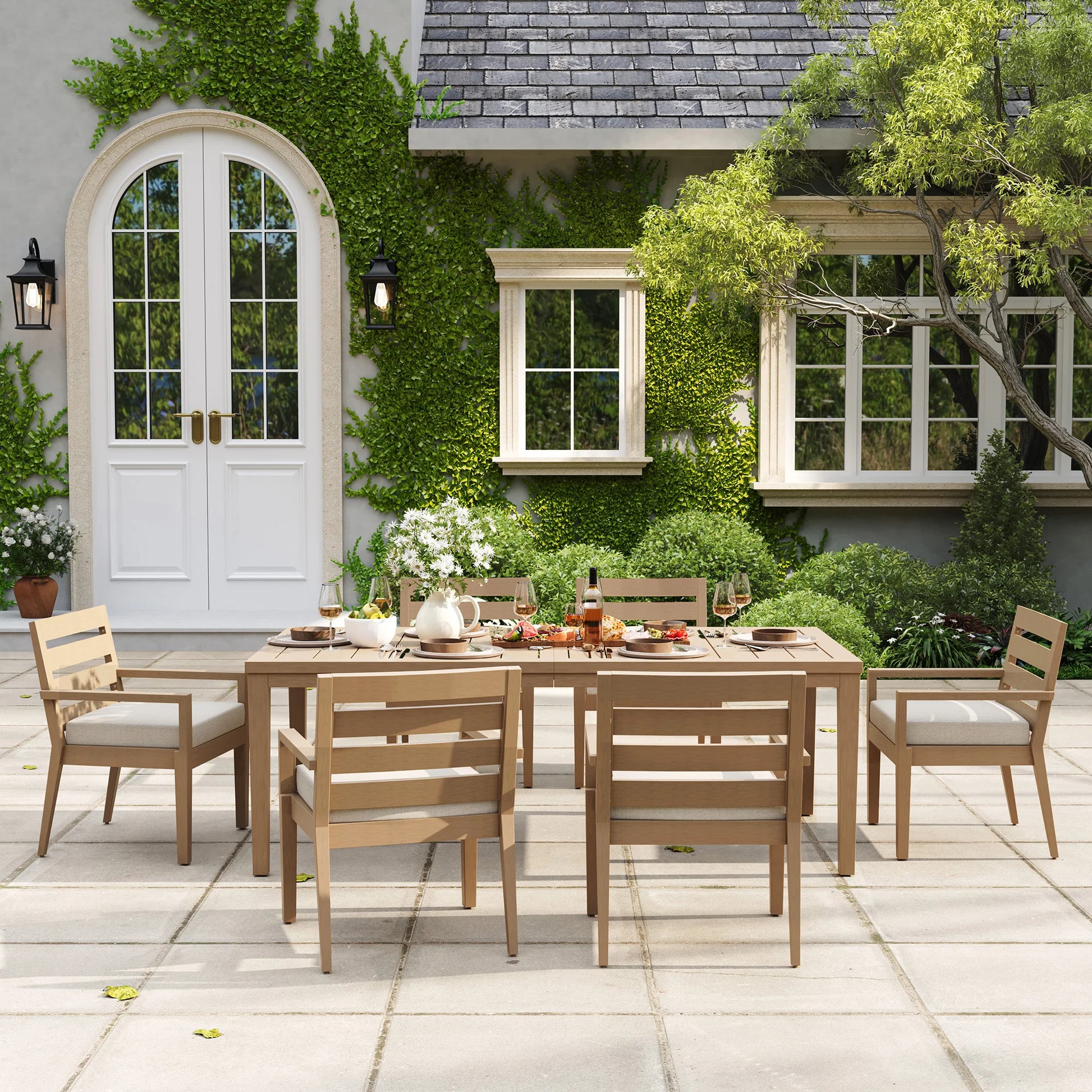 Symmetrical eye-level view of the rectangular Alcudia outdoor dining table set with six classic stationary chairs beautifully set for a family dinner.