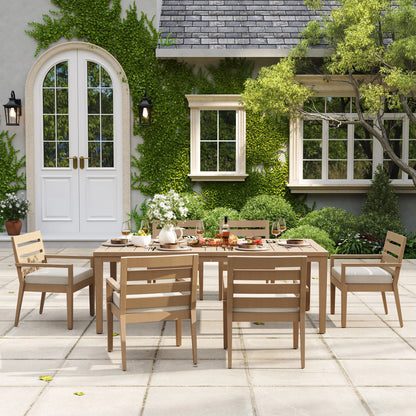 Symmetrical eye-level view of the rectangular Alcudia outdoor dining table set with six classic stationary chairs beautifully set for a family dinner.