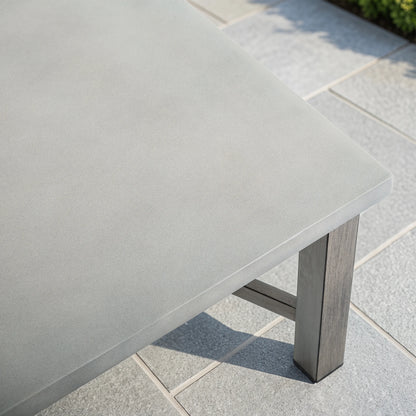 Gray outdoor table with wood-look leg on a tiled patio