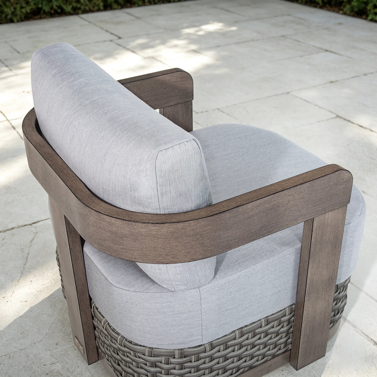 High-angle top view highlighting the architectural curved backrest and light gray fabric cushion of the Manarola patio lounge chair.