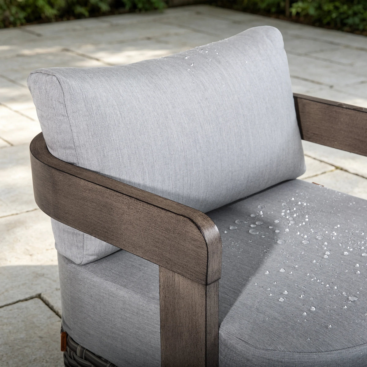 Close-up of water droplets beading up on the weather-resistant Sunbrella fabric cushion of a Manarola fixed club chair.