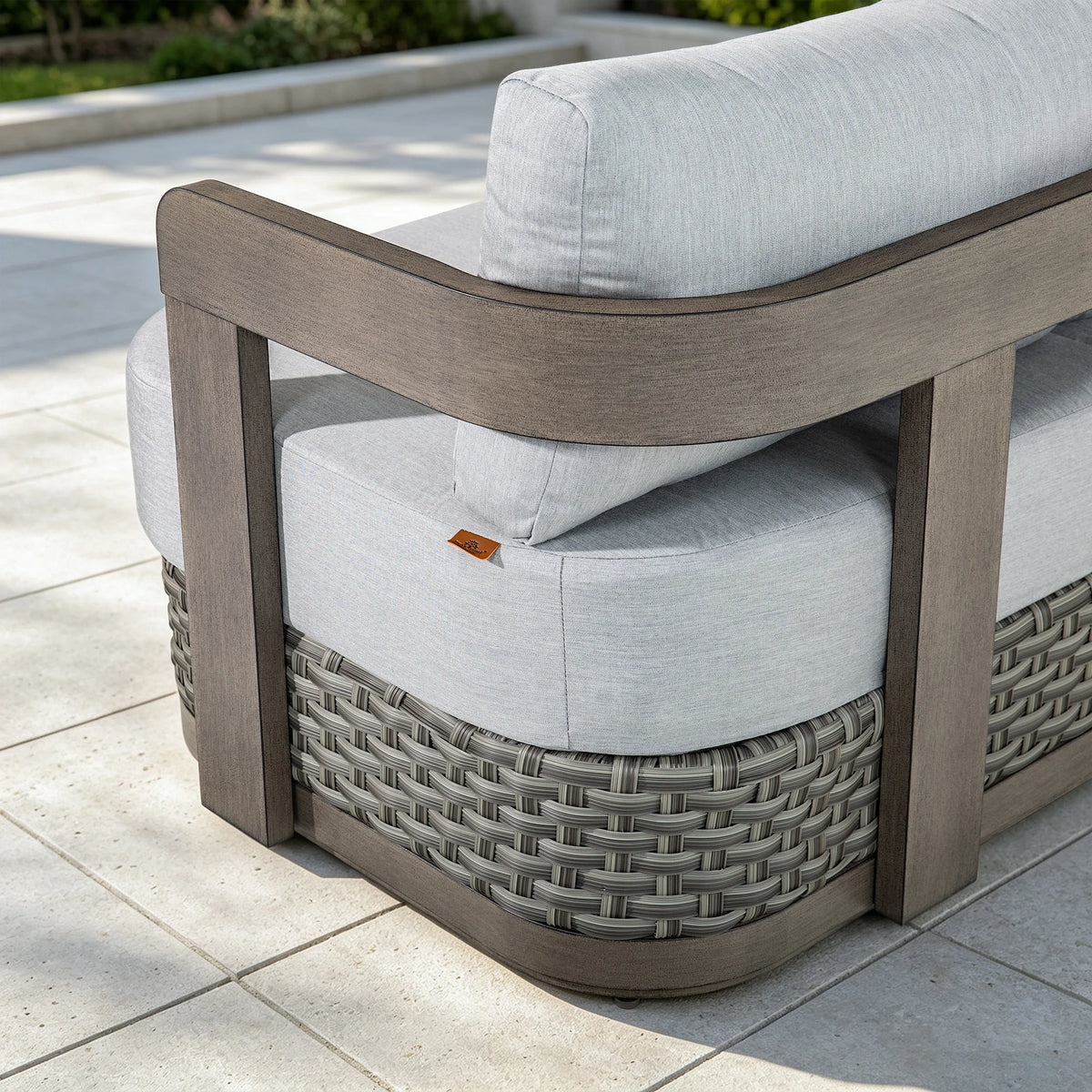Rear-angle close-up highlighting the architectural curved wrap-around aluminum frame with wood-grain finish and woven wicker details.
