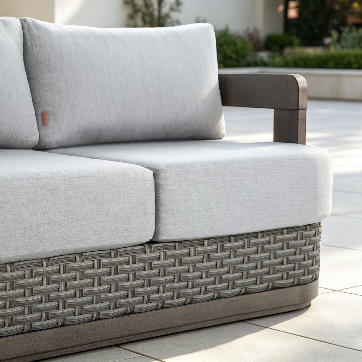 Close-up perspective of the ultra-plush 6.5-inch thick gray Sunbrella seat and back cushions styled on a sunny backyard deck.