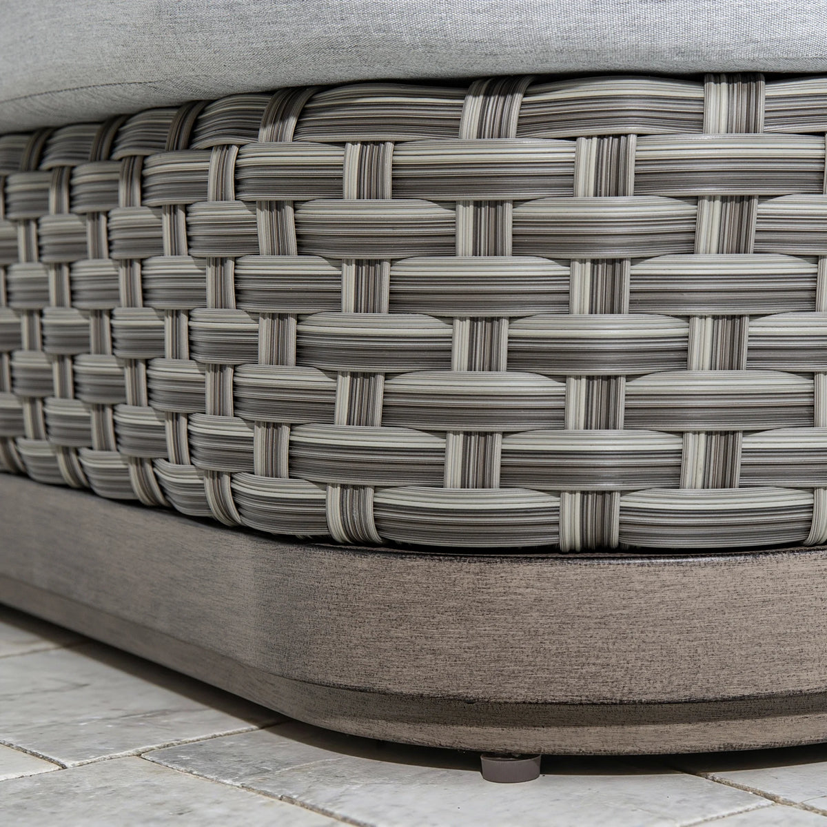 Close-up texture shot of the premium multi-tonal gray PE wicker hand-woven base underneath the non-swivel aluminum frame profile.
