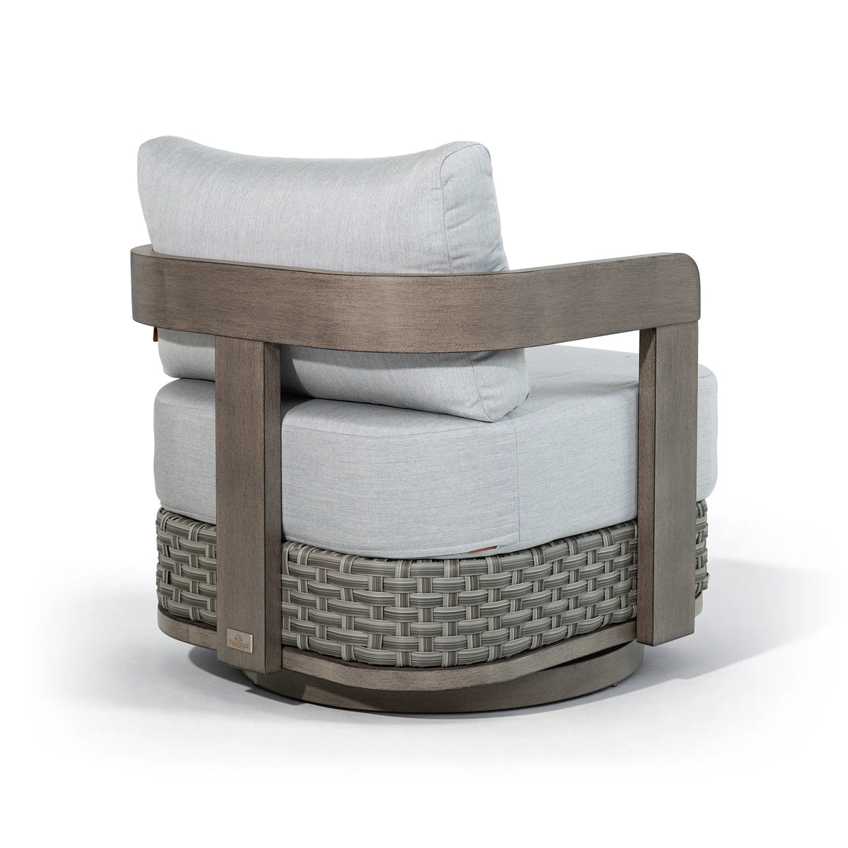 Studio product shot showing the rear angle of the Manarola outdoor lounge chair, highlighting its architectural curved frame and woven wicker skirt.