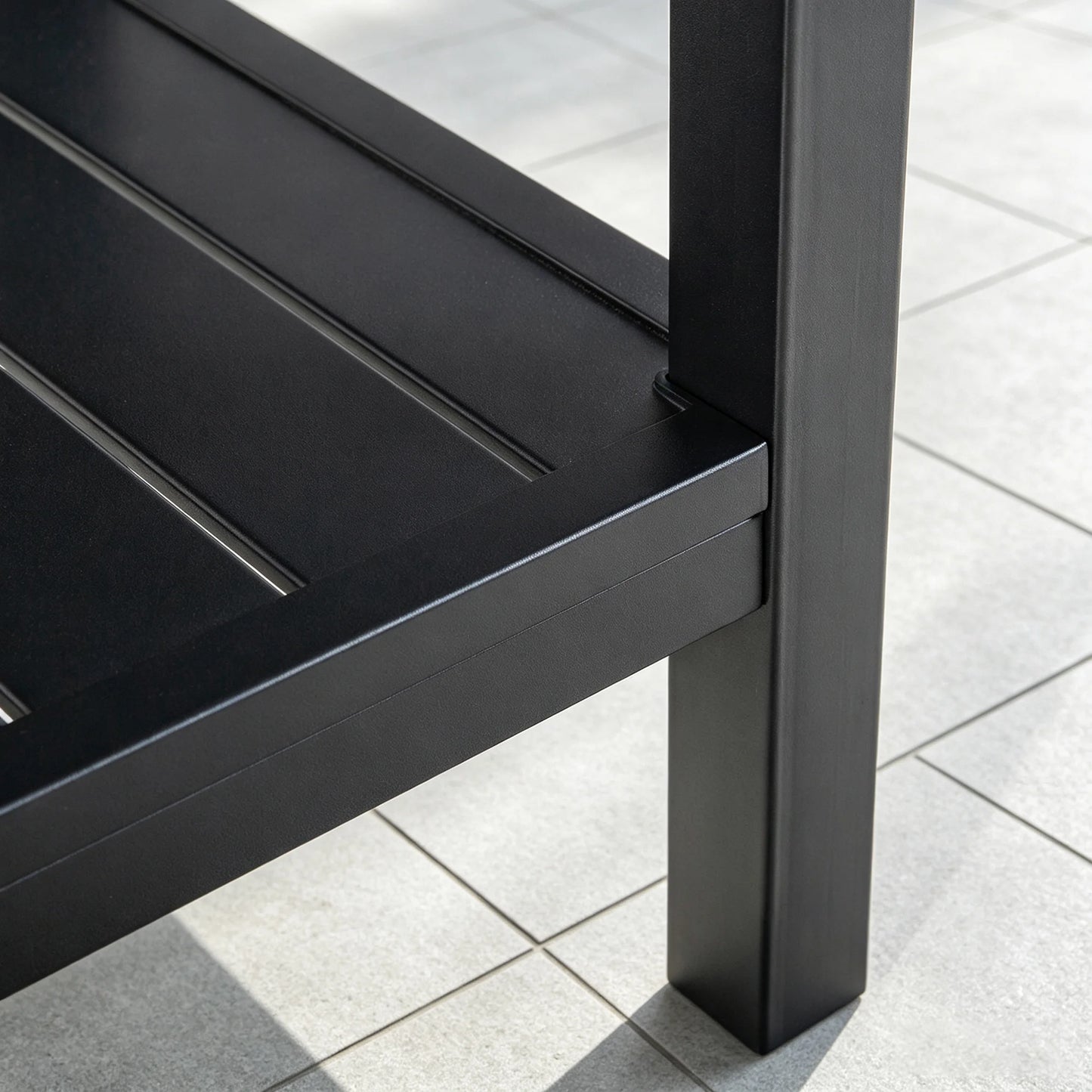 Detailed view of the bottom shelf connection point and heavy-duty welded leg structure of the Saporta accent table.