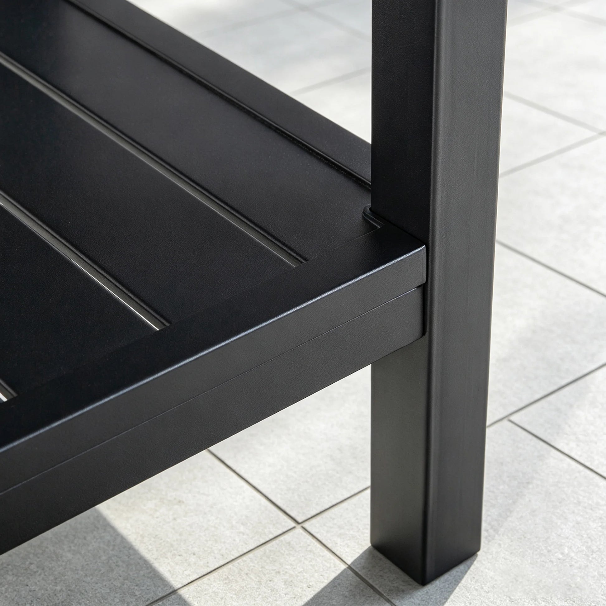 Detailed view of the bottom shelf connection point and heavy-duty welded leg structure of the Saporta accent table.